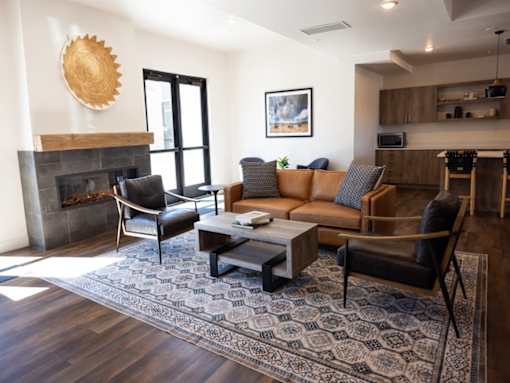 A living room with a fireplace and a large rug.