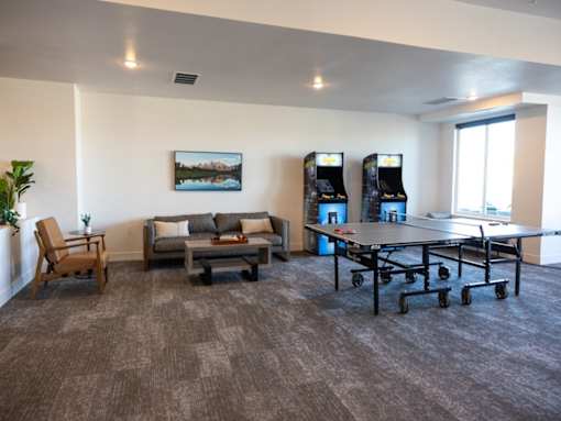 A room with a grey carpet and a painting on the wall.