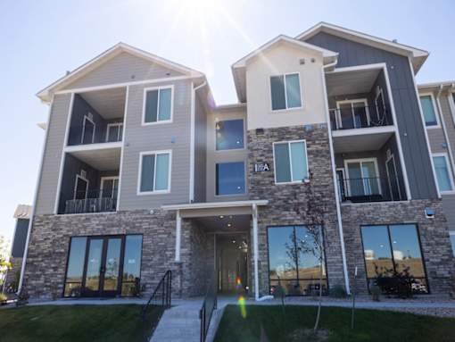 A modern two-story residential building with balconies and large windows.