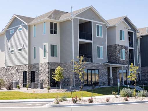 A modern apartment building with stone and siding exteriors.