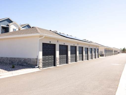 A long row of houses with garages on the side.