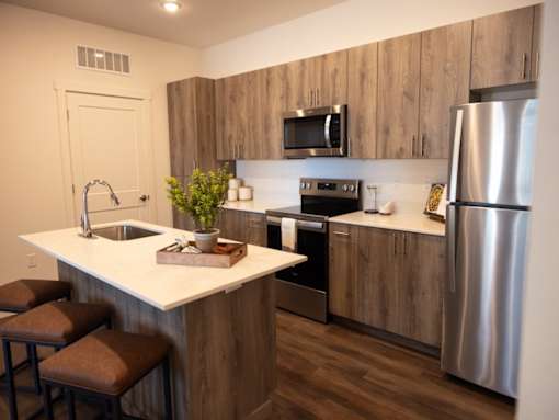 A modern kitchen with a white countertop and stainless steel appliances.