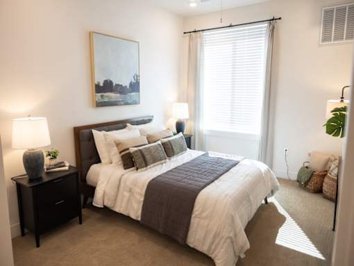 A bedroom with a large bed and a painting on the wall.