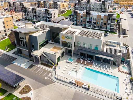 A large building with a pool in front of it.