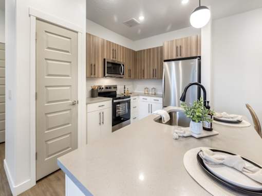 A kitchen with a white countertop and wooden cabinets.