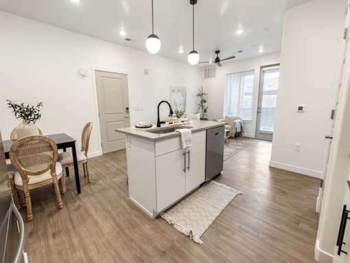 A kitchen with a white cabinet and a grey fridge.