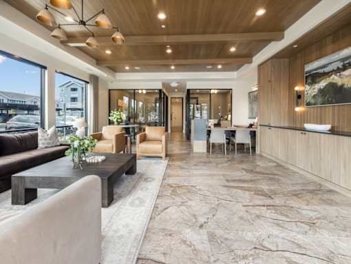 A modern living room with a wooden ceiling and a stone floor.