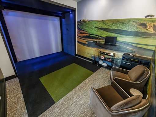 A room with a large screen and a chair.