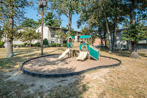 A playground with a green slide and a sandbox at Resident Parking at The District at Forestville Apartments, Forestville, MD, 20747