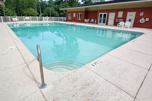 A pool with a ladder in the middle of it. Aviary Village Apartments, in Conway, SC 29526
