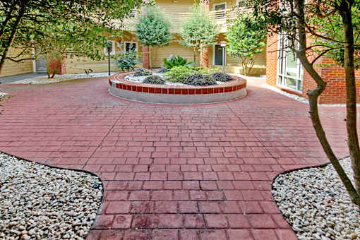 A red brick walkway leads to a house. Aviary Village Apartments, in Conway, SC 29526