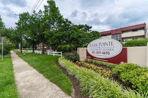 A sign for River Pointe Apartment Homes is displayed in front of a building.