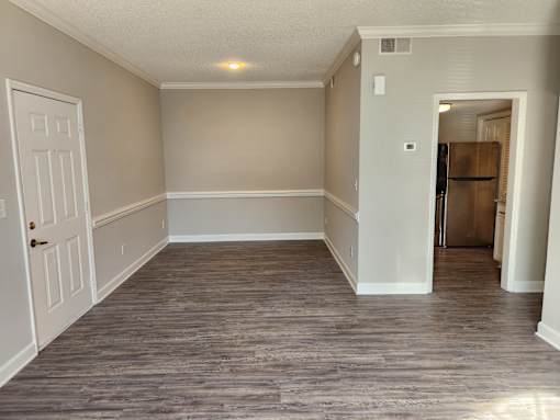 A room with a white door and a grey floor. The Cloisters Apartments, 902 67th Avenue North, Myrtle Beach, SC