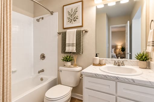 A bathroom with a white toilet, sink, and bathtub.