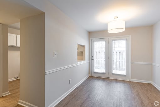 A room with a white door and a window with blinds.