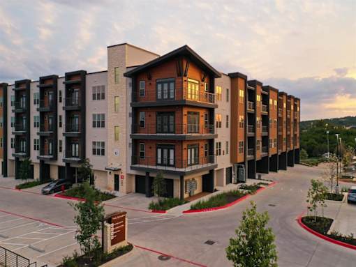 Exterior view of The Shiloh's 4-story apartment building with resident parking.