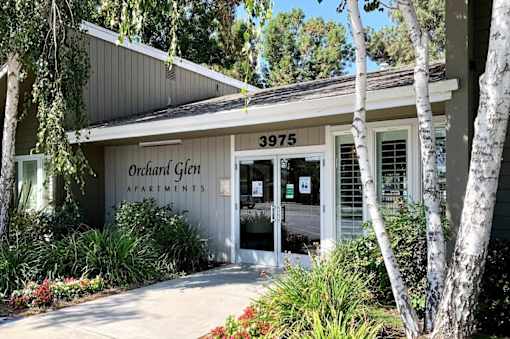 The front of a building with the number 3975 and the words Orchard Glen Apartments on it.
