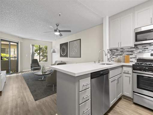 an open kitchen and living room with a large counter top at Harbor Terrace Apartments, San Pedro , CA
