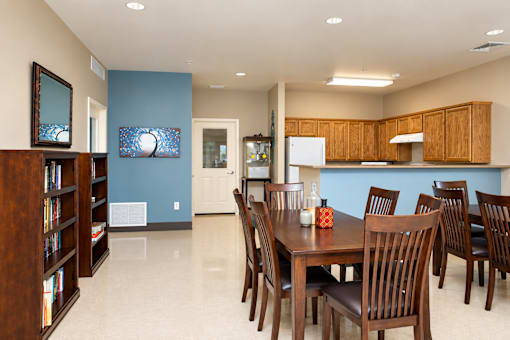 A dining room with a wooden table and chairs.