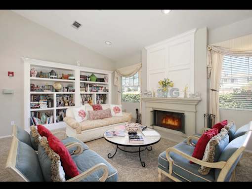 A living room with a fireplace and a bookshelf.