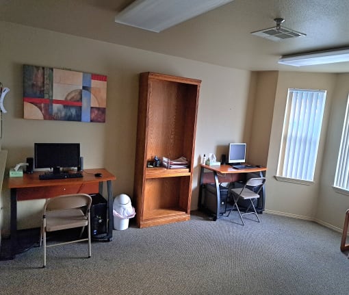 a room with two desks and two computer monitors