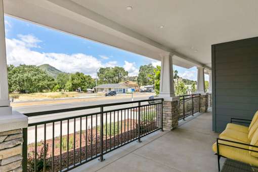 a balcony with a view of a parking lot and a house