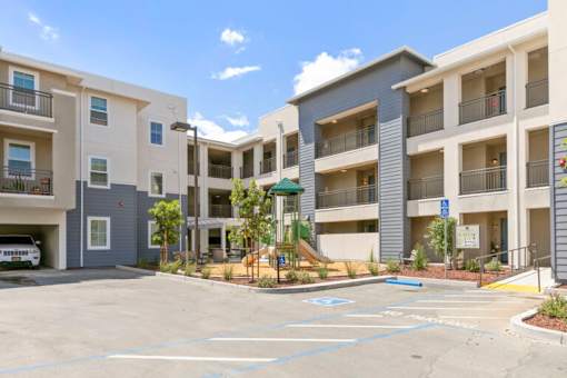 an empty parking lot in front of an apartment building