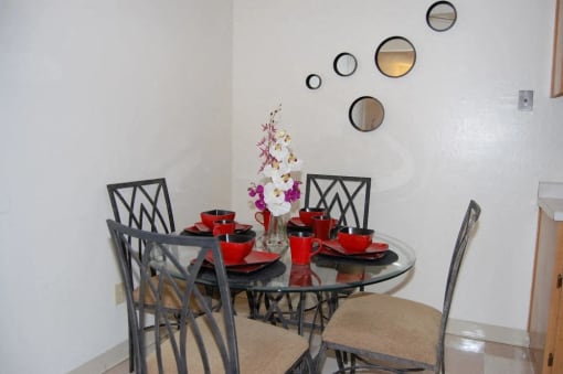 a dining area with a round glass table and chairs