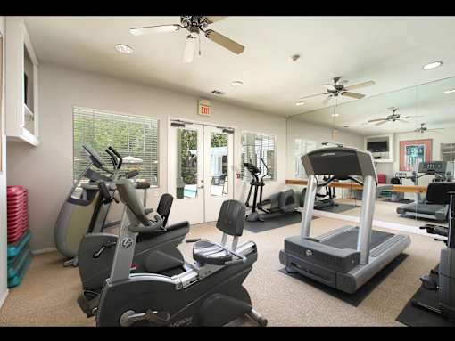 A gym with treadmills, exercise bikes, and other equipment.