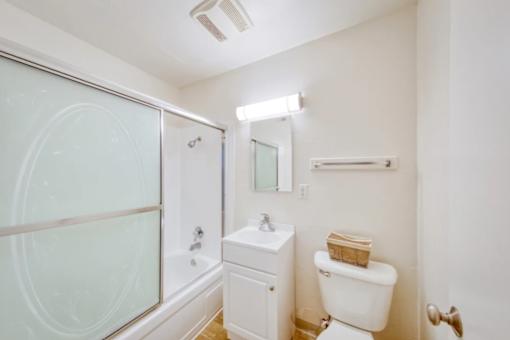 A white toilet sits next to a sink in a small bathroom.