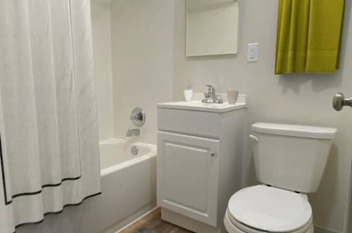 A white toilet sits next to a white sink in a bathroom.