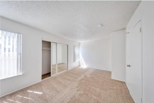 A room with a carpeted floor and a sliding glass door.