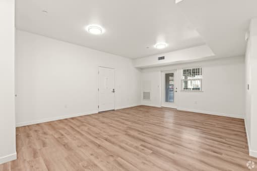 an empty living room with white walls and wood floors