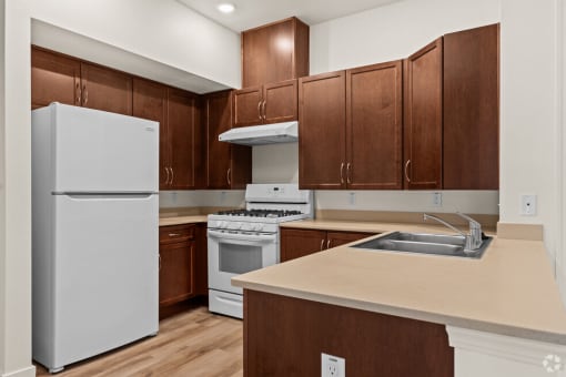 a kitchen with white appliances and wooden cabinets