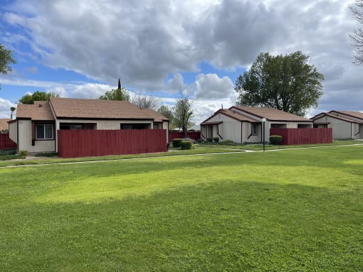a house with a yard and a red fence