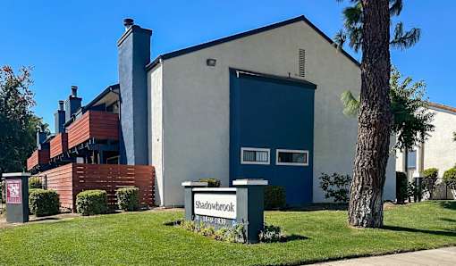 A building with a sign that says Shadowbrook in front of it.
