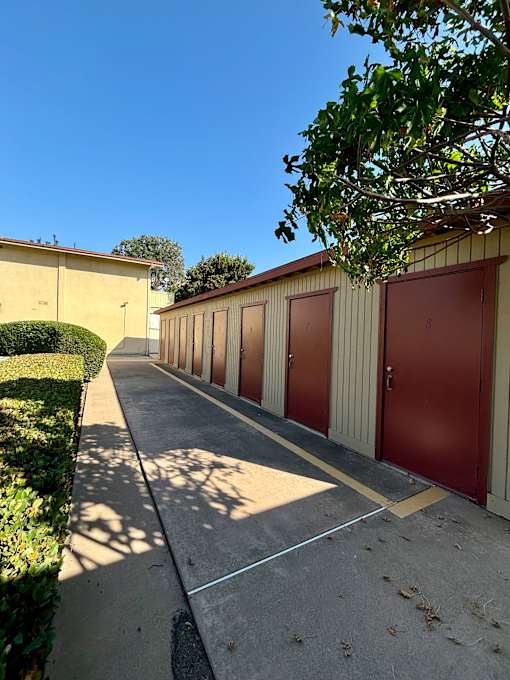 A row of brown garage doors are closed. at The Arbors Santa Ana, California, 92705