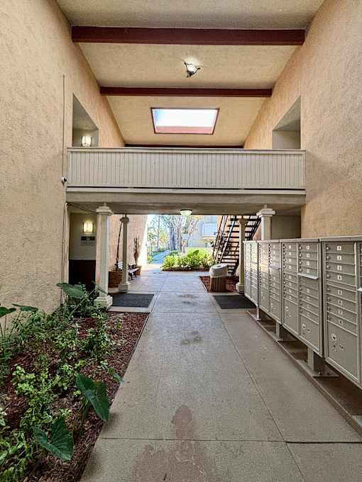 A long hallway with a skylight and a staircase on the right. at The Arbors Santa Ana, California, 92705