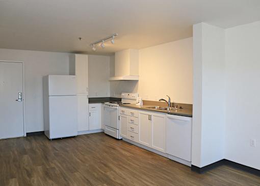A kitchen with white appliances and cabinets.