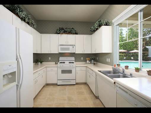 A kitchen with white appliances and cabinets.