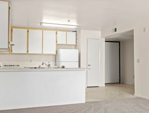 a kitchen with a white counter top and a white refrigerator