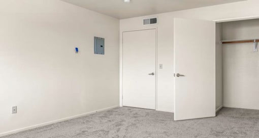 a bedroom with a door to a closet and a carpeted floor