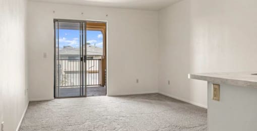 an empty room with a sliding glass door and a balcony
