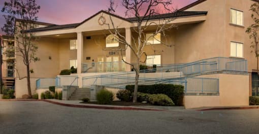 a large tan building with a tree in front of it