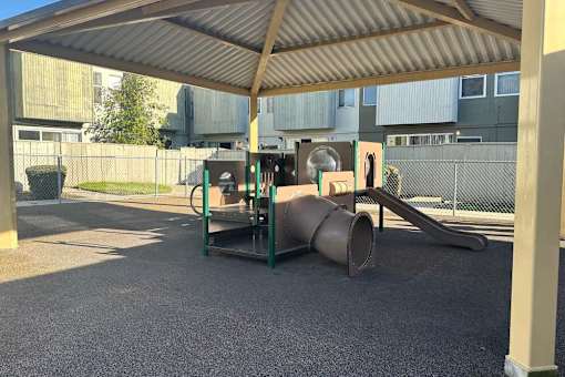 A playground with a slide and a seesaw.