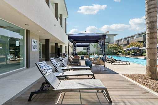 A poolside area with lounge chairs and a canopy.