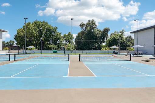 A tennis court with a net and two benches.