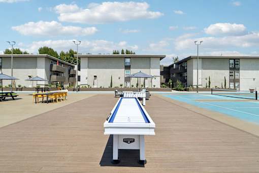 A shuffleboard court is in the middle of a resort area.