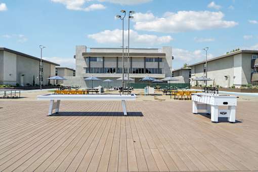 A wooden table is in the middle of a wooden deck.