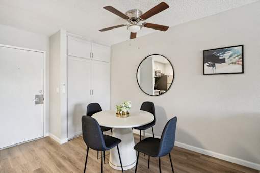 A dining room with a white table and four chairs.
